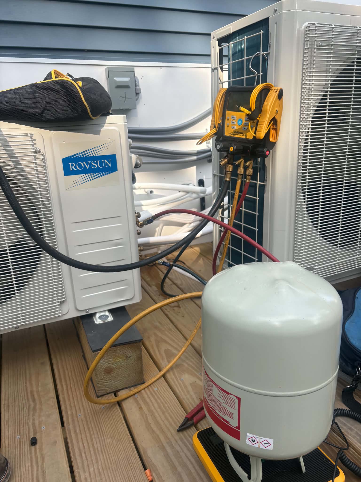 Ductless mini-split outdoor unit installed by Ala & Sons, connected to gauges during startup